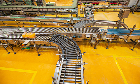 roller conveyor system in industrial facility showing curved powered and gravity roller sections