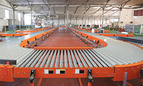 roller conveyor system with straight and curved sections installed in an industrial warehouse for efficient and flexible material handling