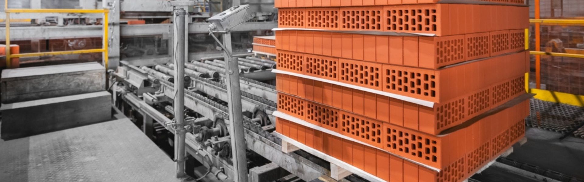 pallet conveyor systems handling heavy brick loads in a durable industrial material handling line